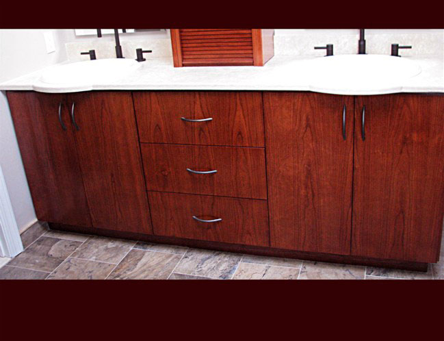 Stained Cherry Bathroom Vanity. Double sink with center drawers. Above vanity upper cabinet.